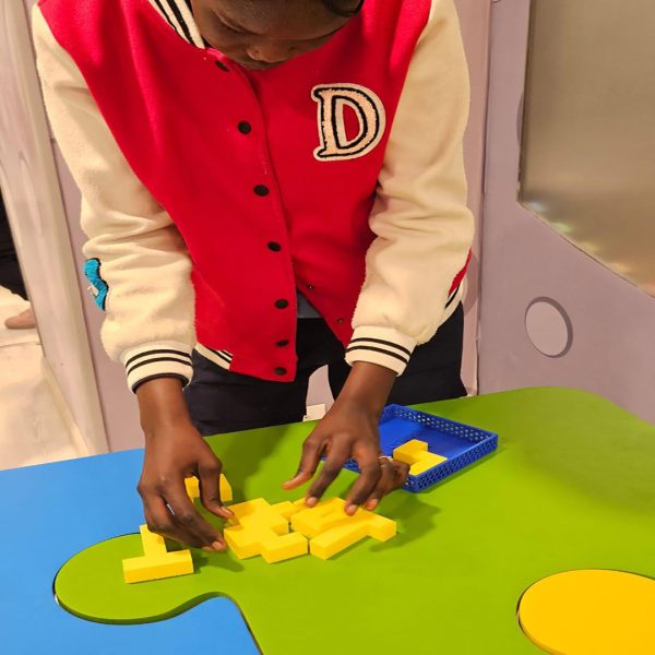 Refugee child displaying a creative project during a UNHCR educational session focused on early development